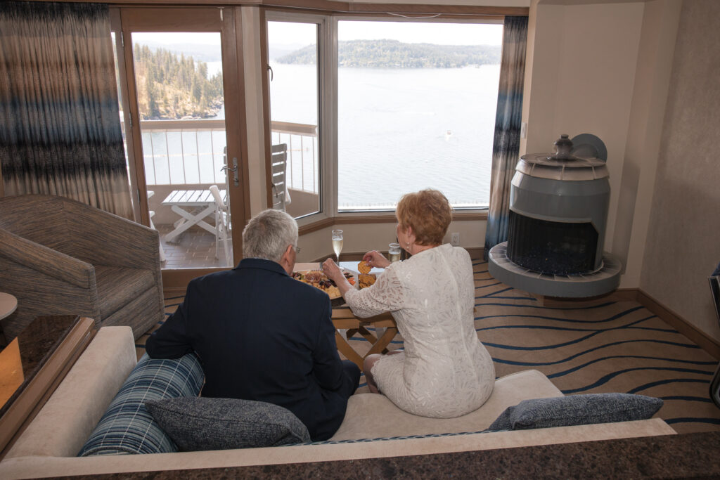 Bride and groom sitting together enjoying their meal and lake view.