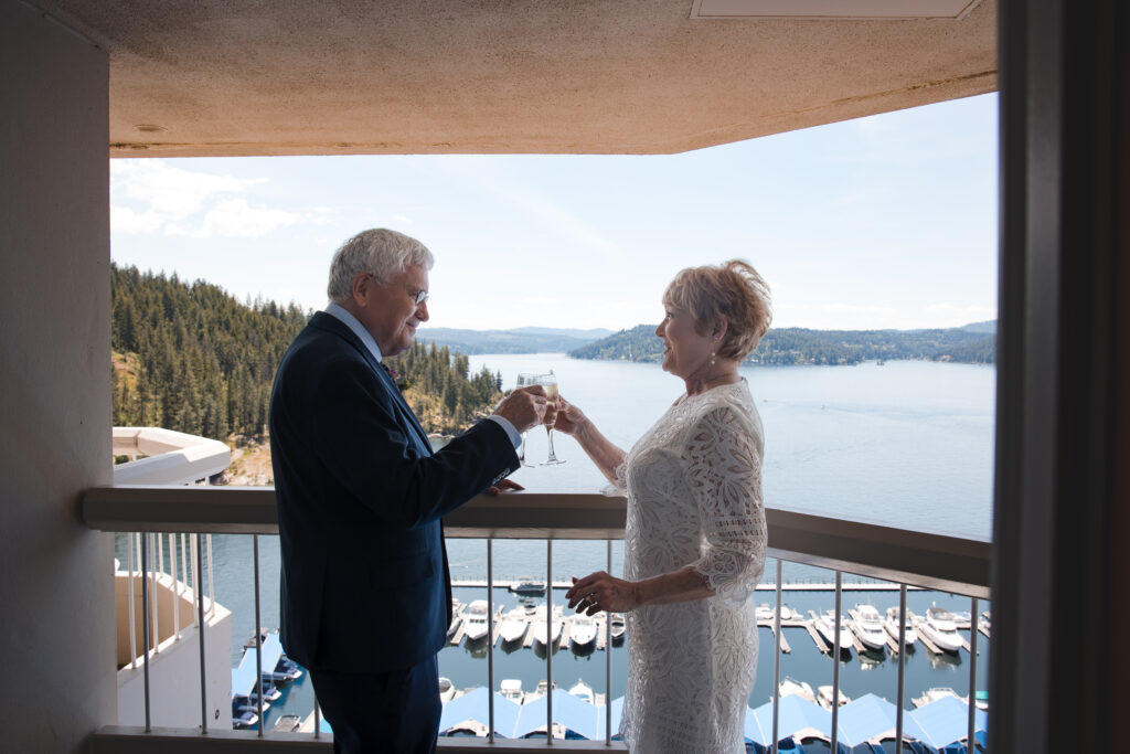 Couple toasting on their balcony overlooking Lake Coeur d’Alene.