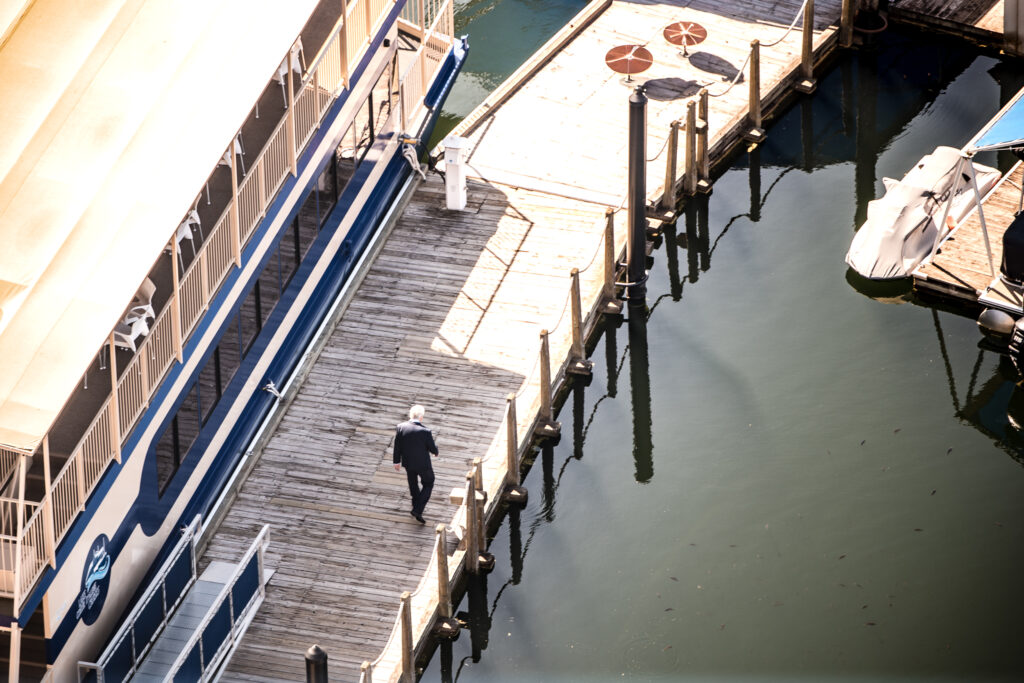 Groom walking along the dock at Coeur d’Alene Resort for first look