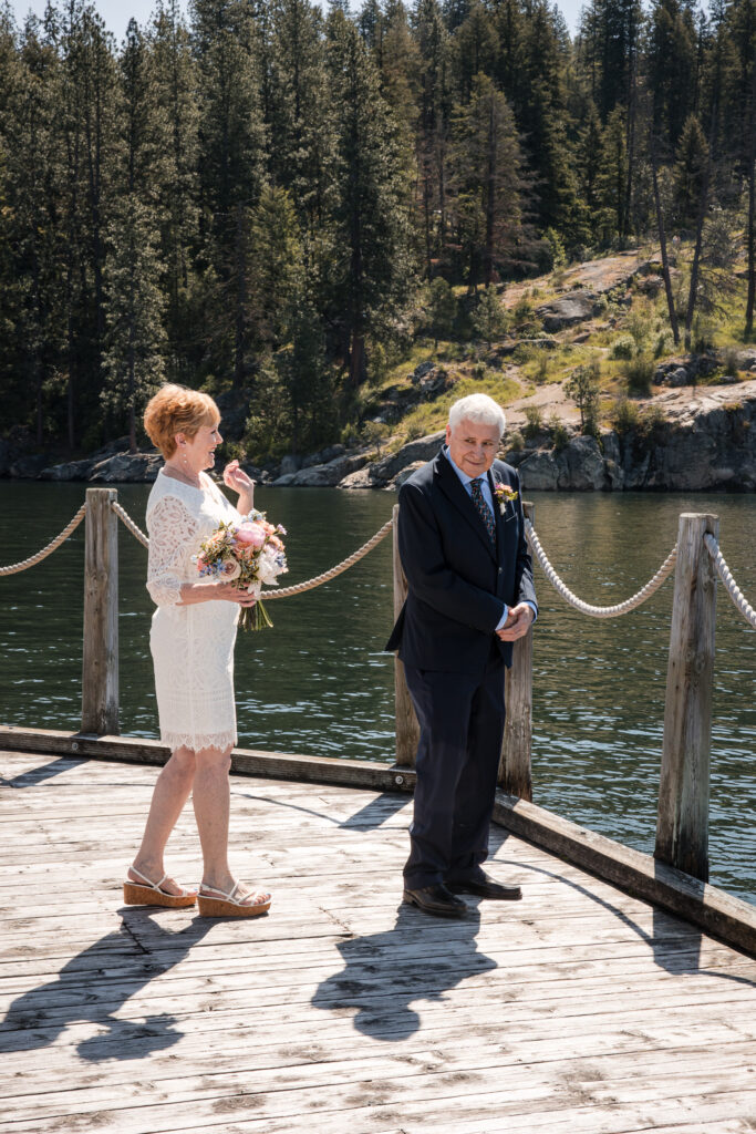 Bride approaching groom from behind for first look on the dock