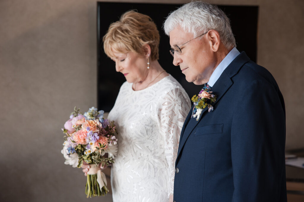 Bride and groom standing close with heads bowed in a quiet moment