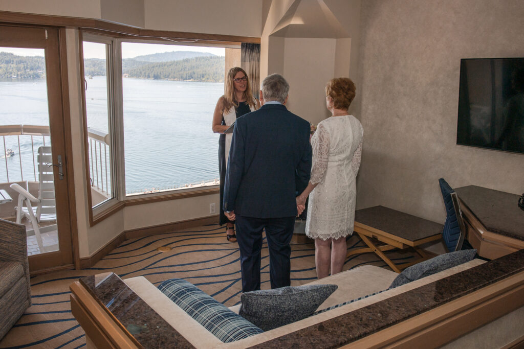 Couple standing hand in hand during elopement ceremony in lakeview suite
