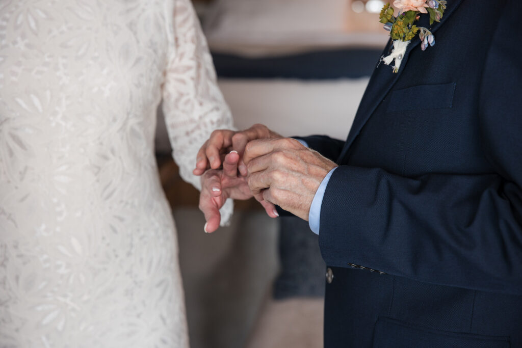 The groom is placing a ring on the bride.