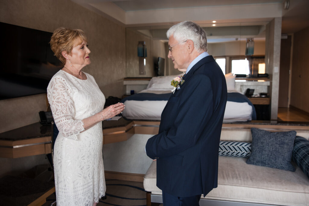Couple sharing ring exchange in hotel ceremony.