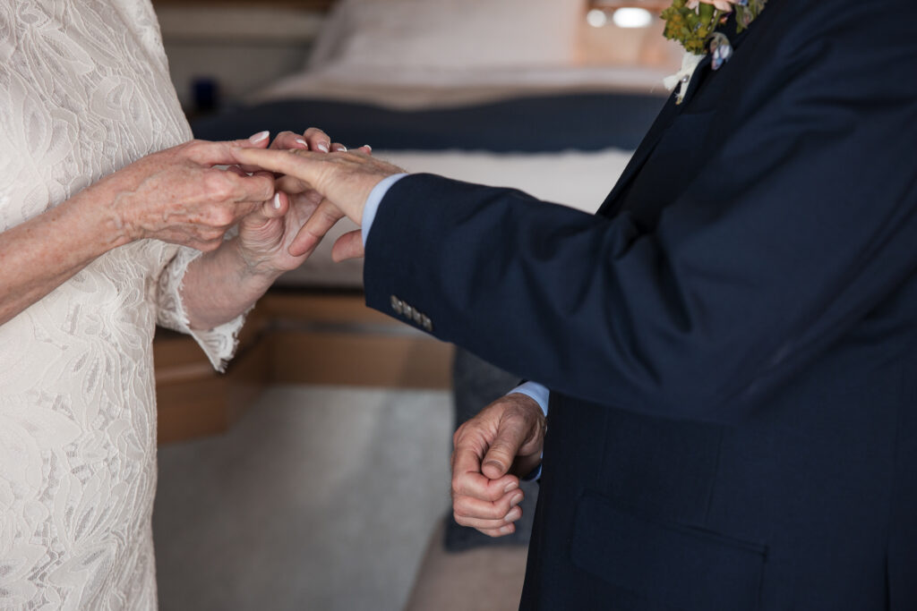 Bride placing ring on Groom.