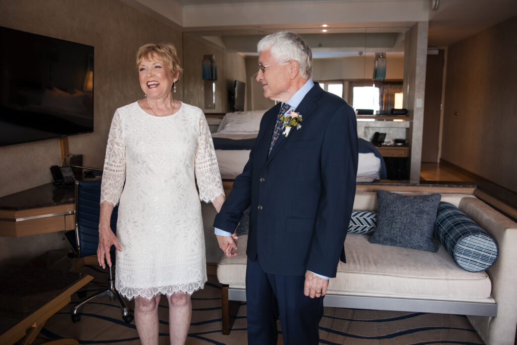 Bride laughing joyfully while holding groom's hand after ceremony