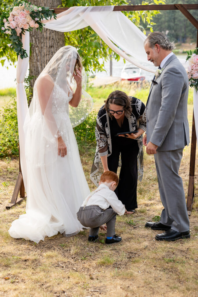 A young boy drops rings while handing them to the officiant.