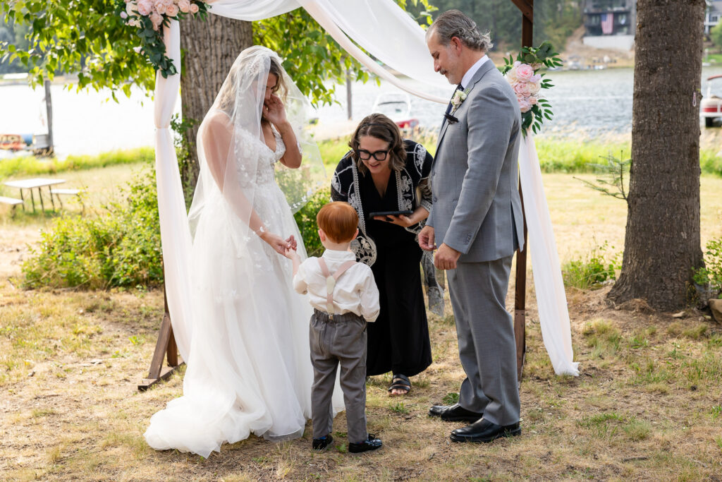 Young boy bringing rings to bride and groom during ceremony.