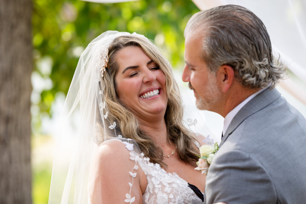 Sweet moment between the bride and groom, both are smiling in joy.