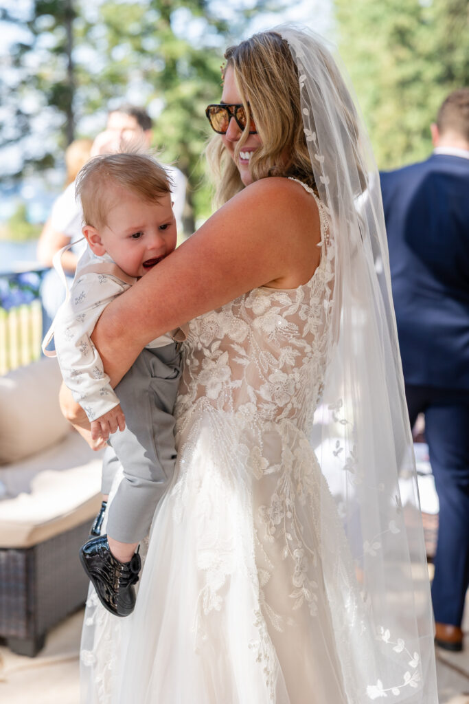 Bride dancing with baby in her arms dancing on the deck