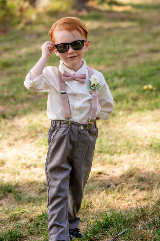 Young boy smiling and striking playful poses after cake cutting.