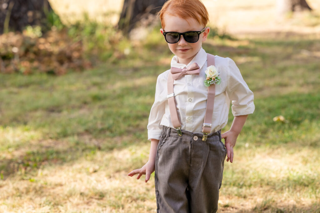 Young boy smiling and striking playful poses after cake cutting.