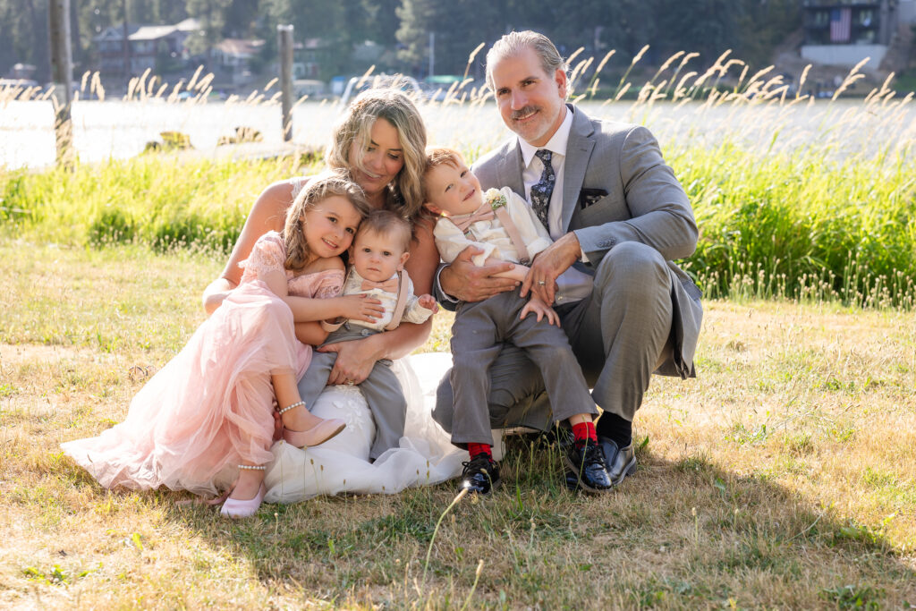 Bride, groom, and kids all snuggled together for a family portrait.