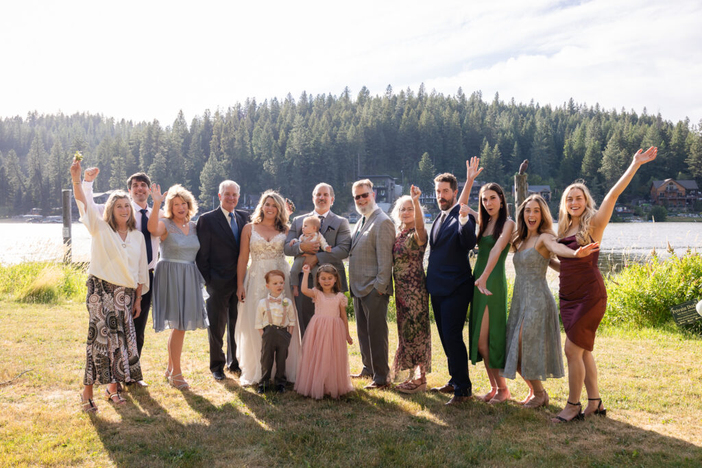 Blended family and relatives gathered for portraits with the lake in the background.