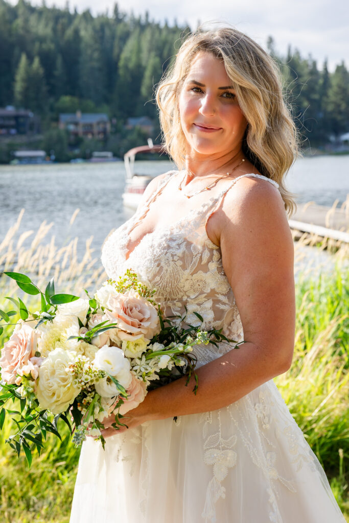 Bride looking at camera for portrail by the lake