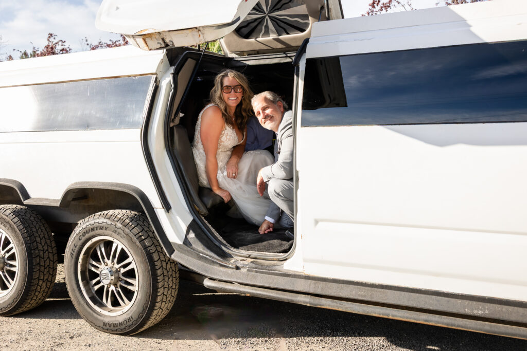 Newlyweds pulling away in limo with soft golden light over Lake Coeur d’Alene.