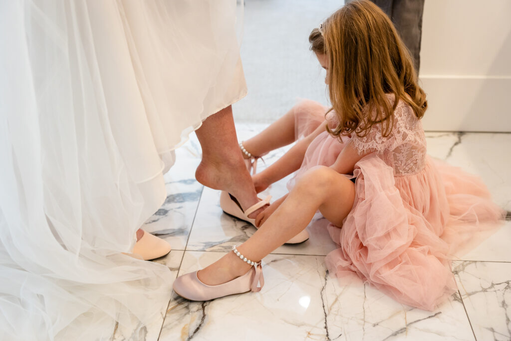Bride’s daughter helping her slip into wedding shoes at Lake Coeur d’Alene Airbnb.
