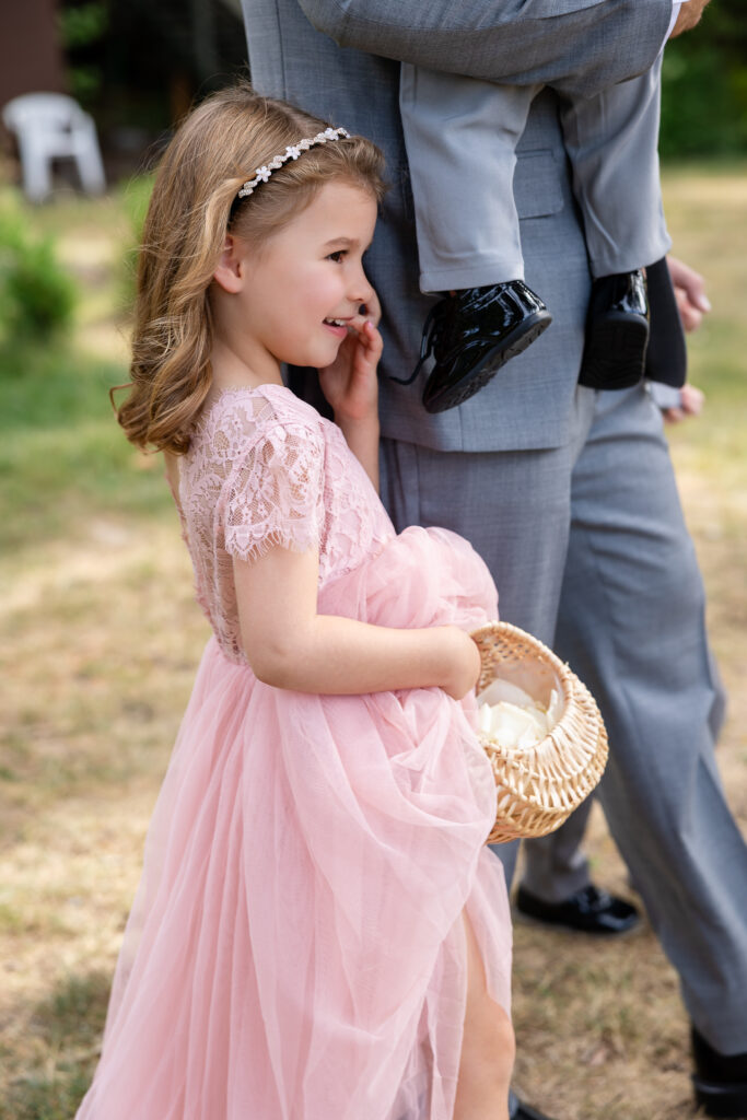 Daughter dressed in pink standing at her fathres side.
