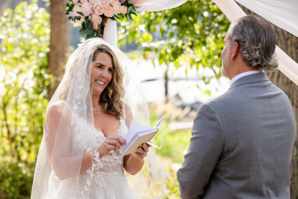 Bride smiling, reading vows during the ceremony.