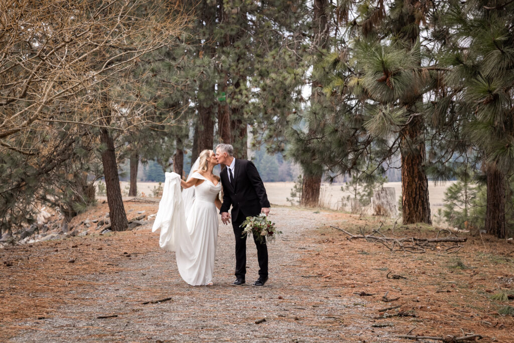 Bride and groom walking on a forest trail in Coeur d’Alene
